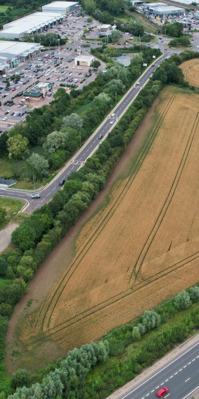 Drone capture of a highway, agricultural field, and shopping center in Bedford, England.